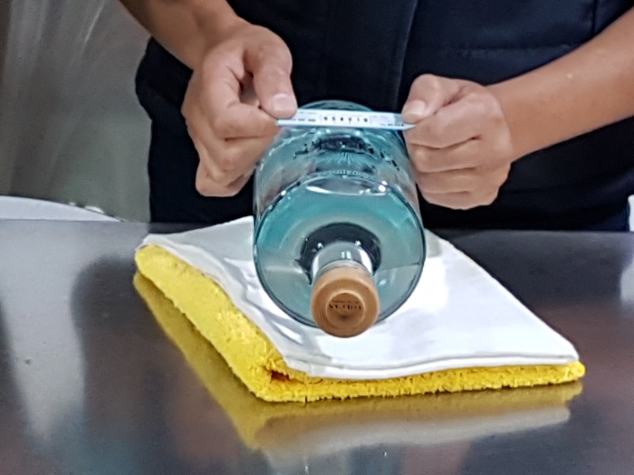 Labelling a bottle by hand at the Volcan de mi Tierra tequila distillery in Jalsico in Mexico