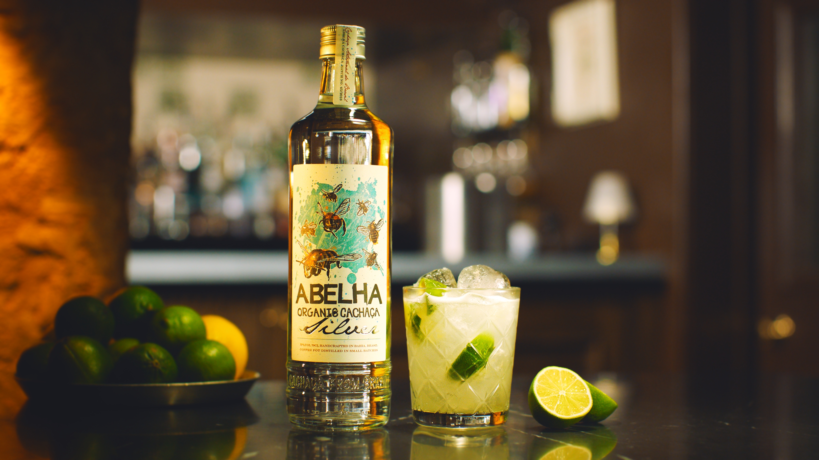 A Caipirinha cocktail and a bottle of Abelha Organic Cachaca from Brazil