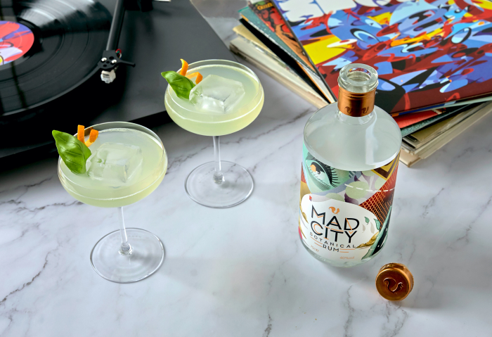 Bottle of Mad City Botanical Rum with a cocktail