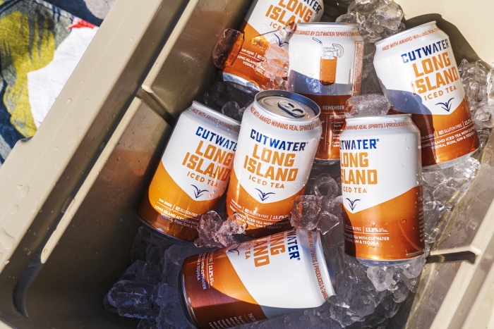Cutwater Canned Cocktails Long Island Iced Tea cans in a cooler on the beach