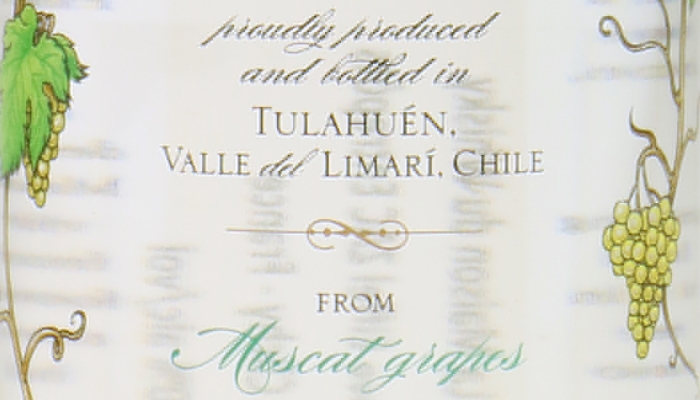 Detail from the label of a bottle of Pisco Waqar from Chile and made from Muscat grapes