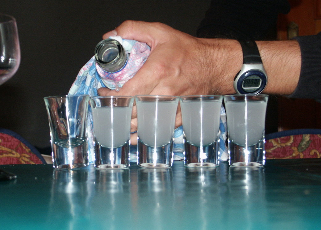 Pouring Glasses of Ouzo