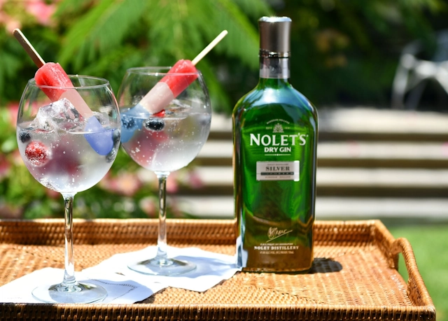 Bottle of Nolet's Gin and two gin cocktails