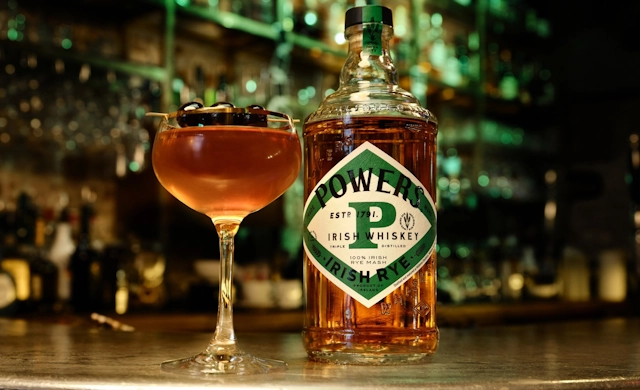 Bottle of Powers Irish Rye Whiskey with a Whiskey Cocktail